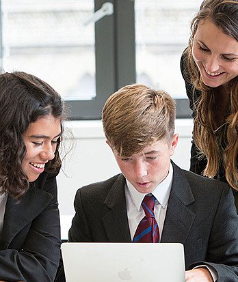students collaborate around computer Hero 